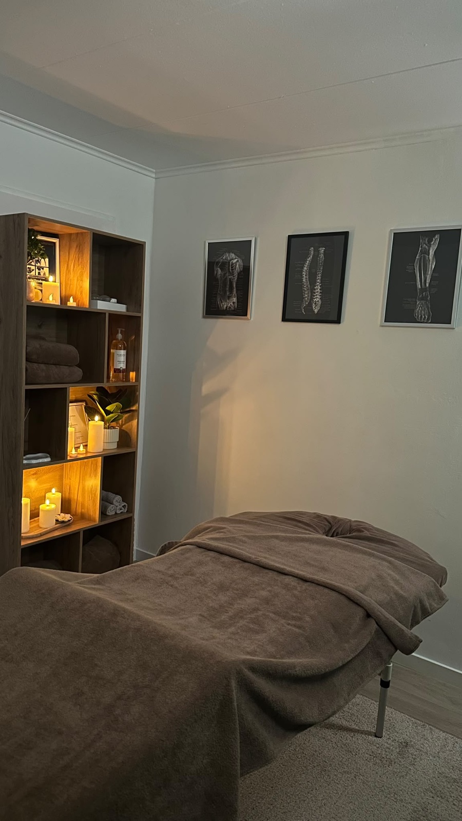 De behandelkamer van de praktijk in Heerhugowaard, met massagetafel en kaarslicht